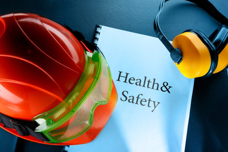 Health and Safety binder with a construction helmet on top